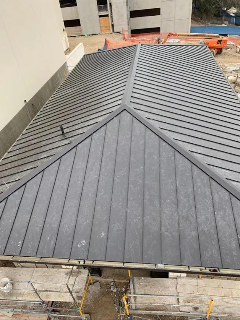 Commercial metal roof construction with crane equipment in Wells